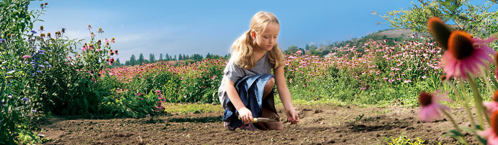 VD_CommunityInvolvement_1030x300-tinify Jeune fille semant des graines dans un jardin communautaire entouré de fleurs sauvages.